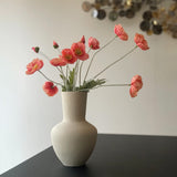 hvid keramikvase med orange blomster