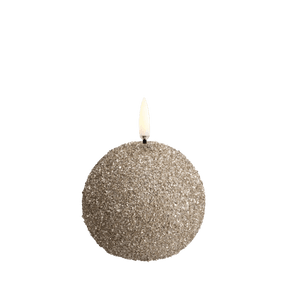 Uyuni LED sneboldlys i champagnefarvet glimmerfinish med livagtig flamme – rund form som en snebold, fotograferet i varm, stemningsfuld belysning.