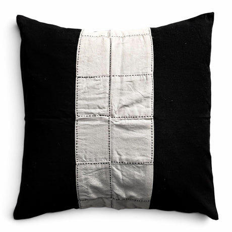 Håndlavet himmerli pyntepude i sort og beige med patchwork-panel og dekorative stikninger i et moderne design.