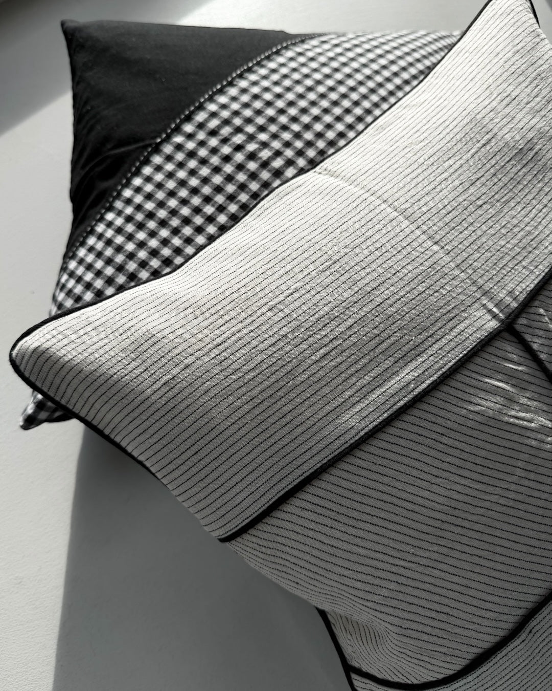 Himmerli dekorativ pude med beige stribet tekstil, sorte kantbånd og grafisk design i skandinavisk stil