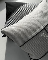 Himmerli dekorativ pude med beige stribet tekstil, sorte kantbånd og grafisk design i skandinavisk stil