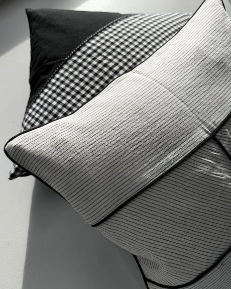 Himmerli dekorativ pude med beige stribet tekstil, sorte kantbånd og grafisk design i skandinavisk stil